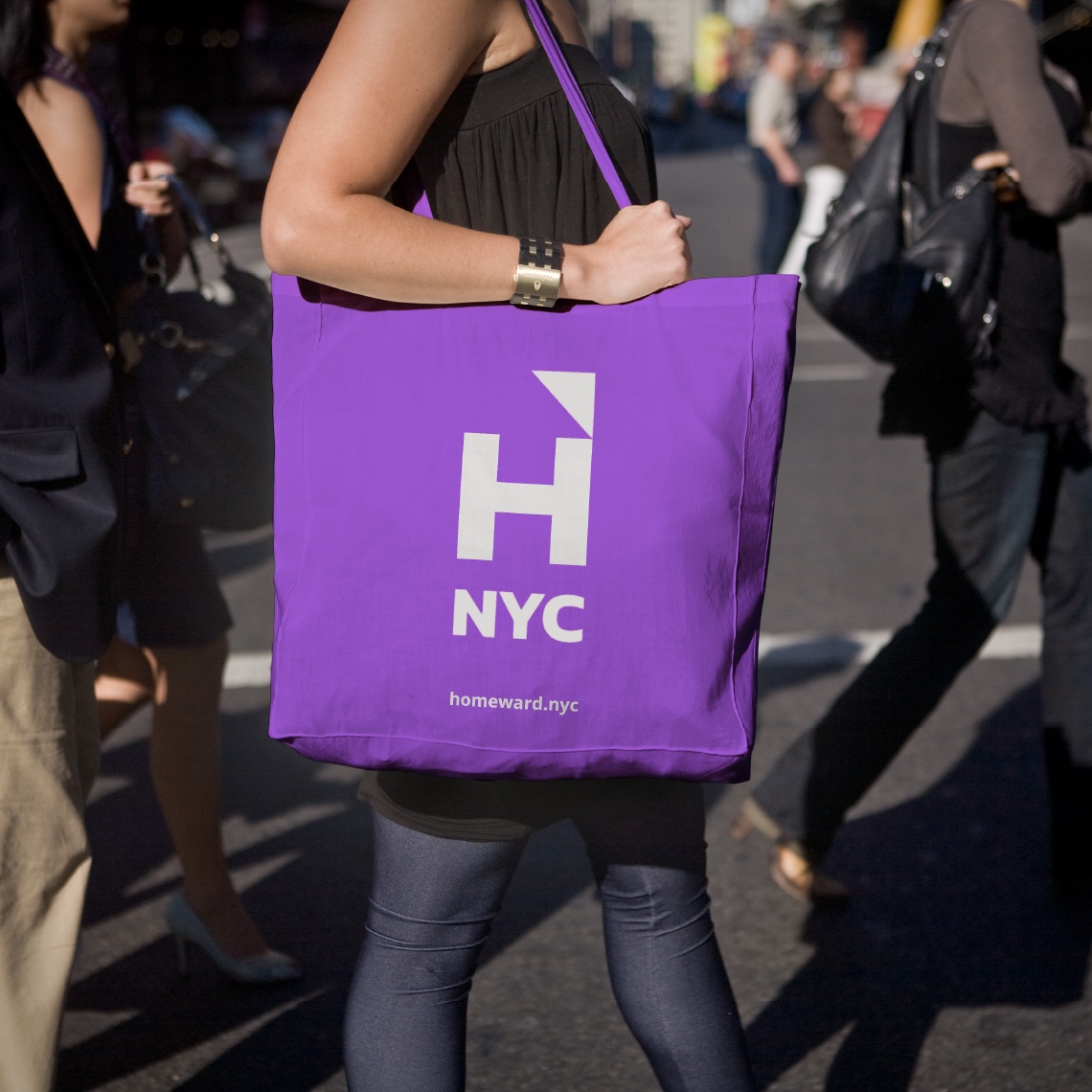 a woman crossing a street with a purple shopping bag with the Homeward UK logo in white, showing how the design system could be represented.