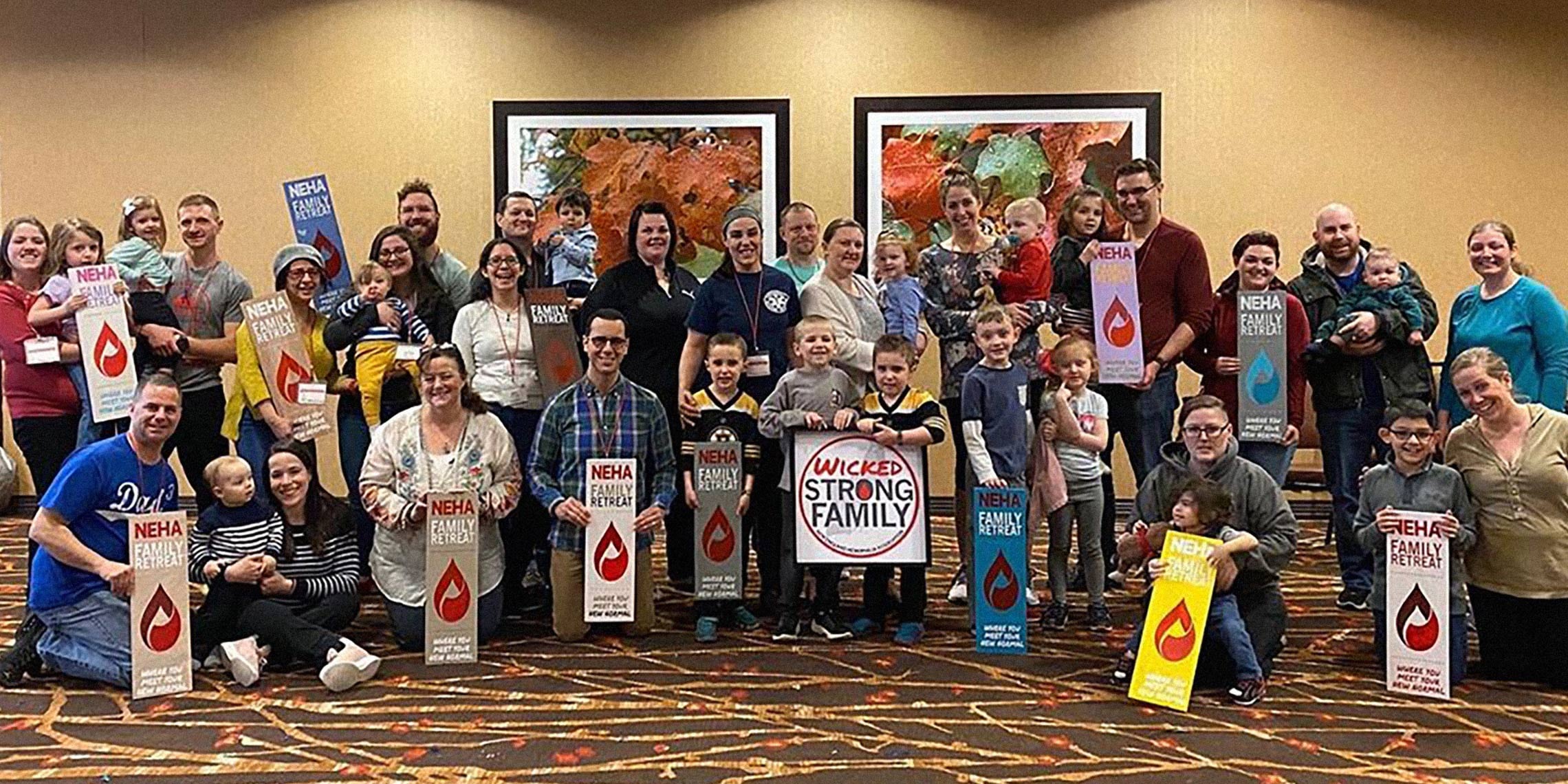 a group of people holding up Neha signs in a room.