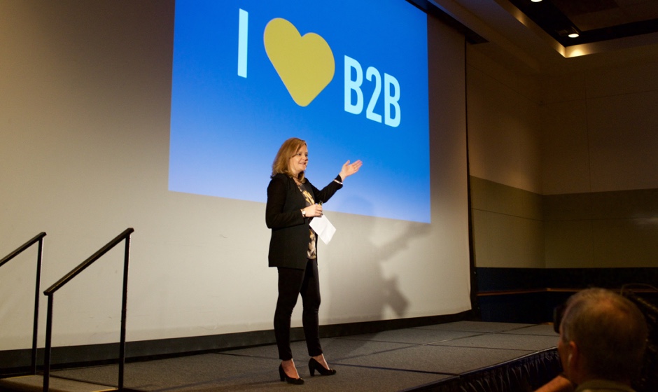 A woman delivering a presentation on stage.