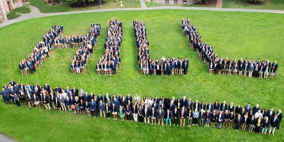 a large group of people standing on a soccer field to form the logo