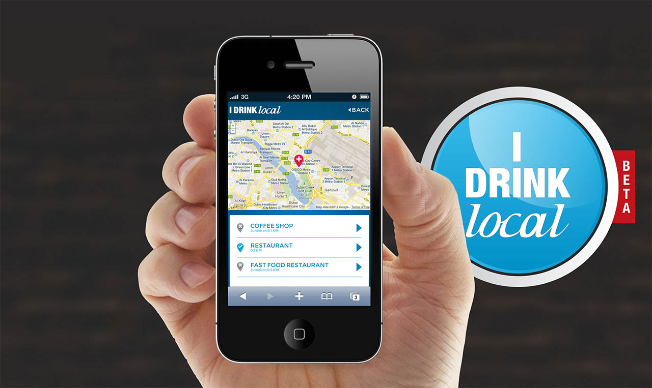 A person holding up a phone with a drink local app for "I Drink Local.