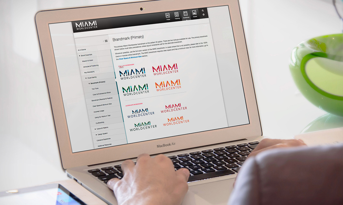 A person using a laptop with a logo on it, showcasing a bold sense of place.