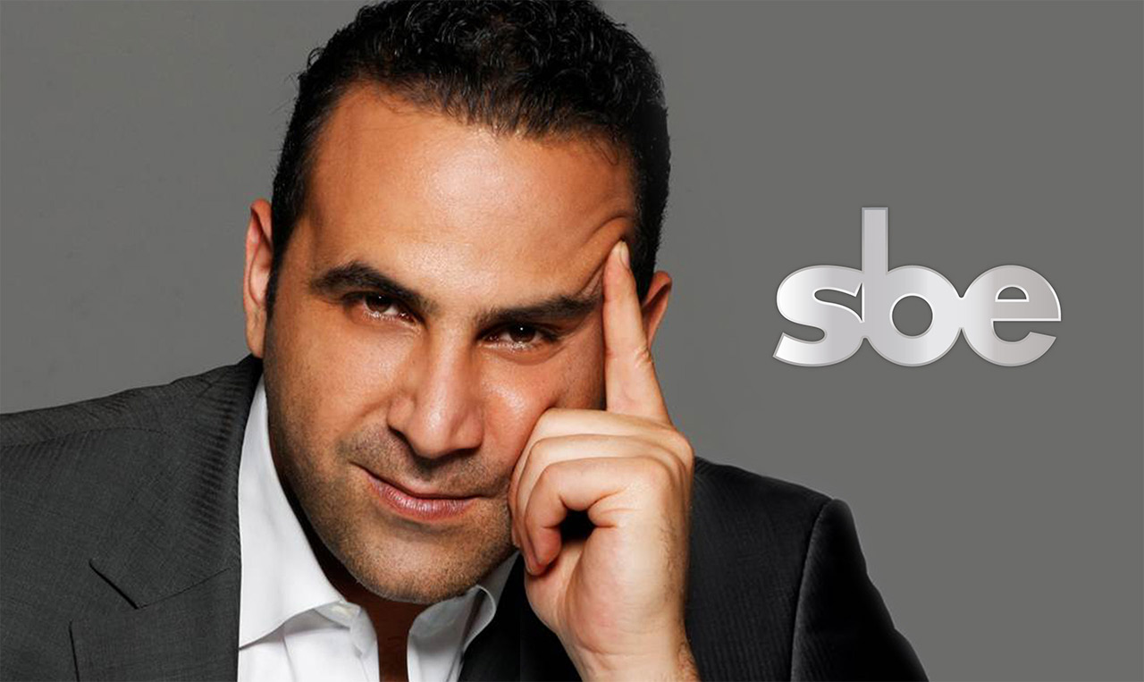 A man in a suit is posing with his hand on his head for brand development.