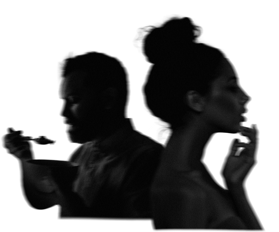a blurred man eating and a blurred woman looking in the mirror