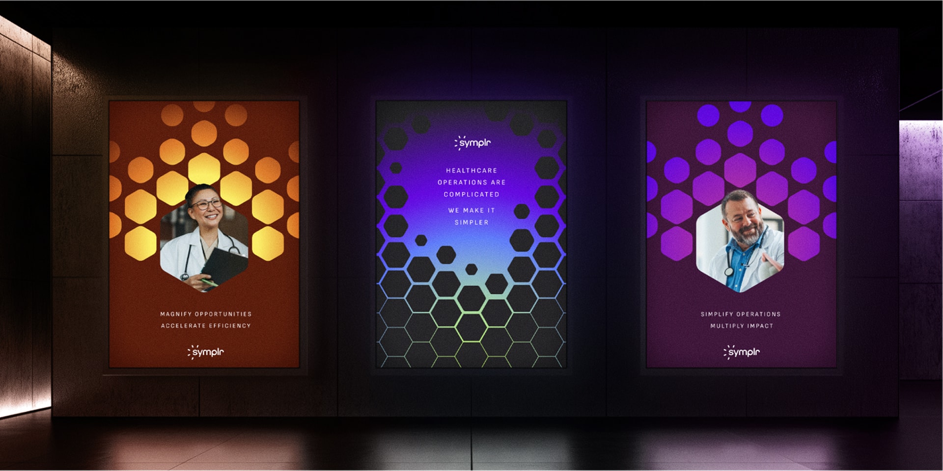 Three vibrant posters featuring various designs displayed on a black wall, promoting the brand 'symplr'